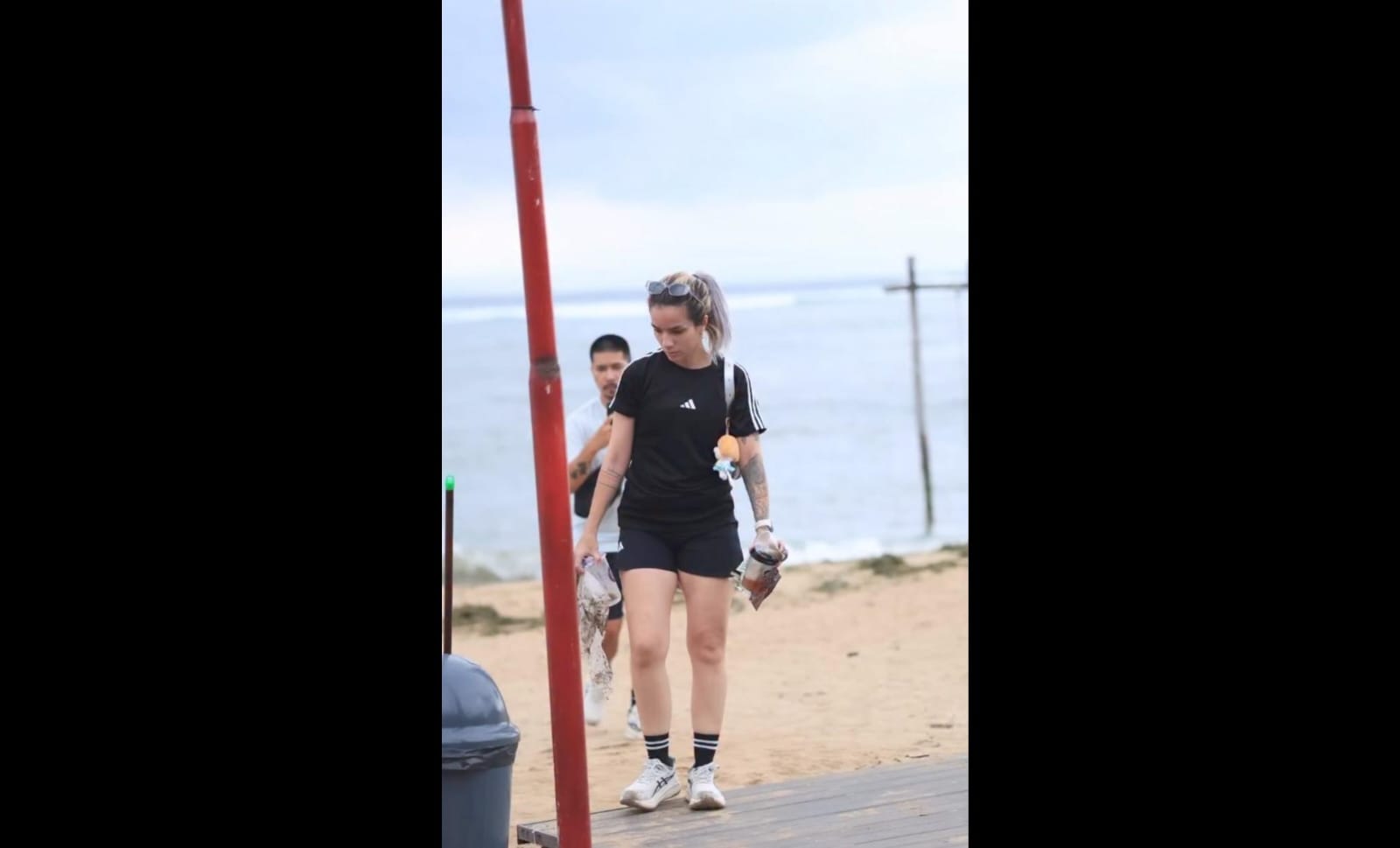Sheila Marcia memungut sampah di Pantai